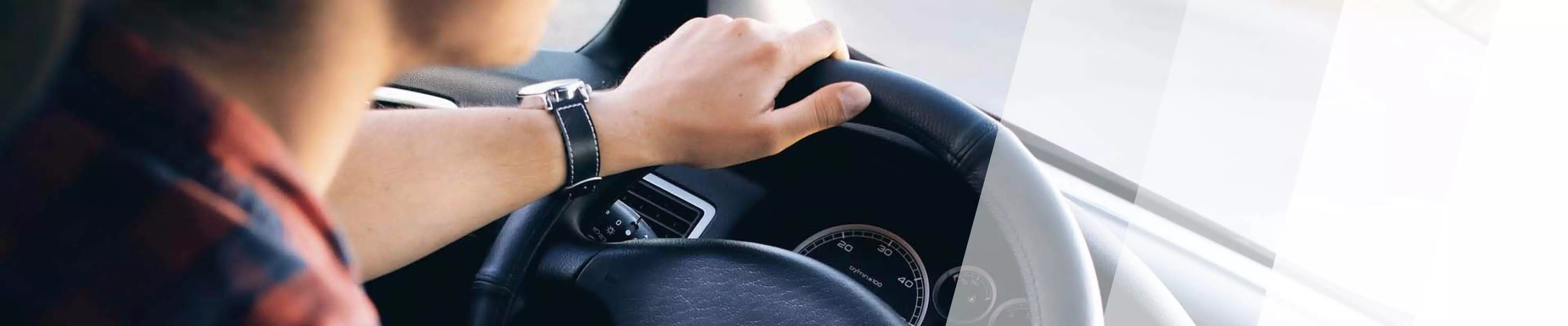 Ein Mann lenkt am Lenkrad eines Autos